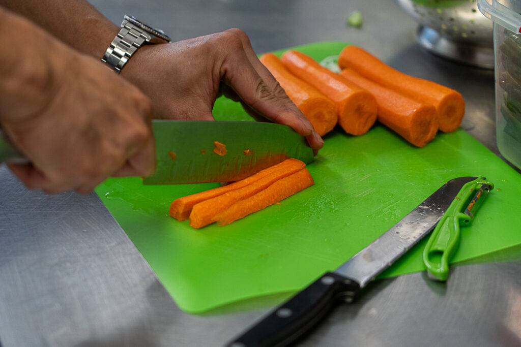 School canteen staff cutting carrots
